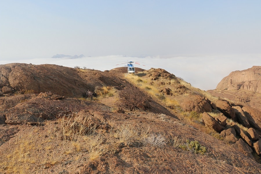 Helicopter on Mountain over Clouds